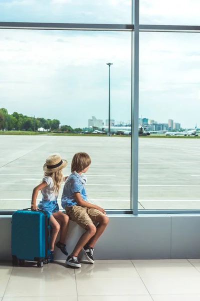 Enfants regardant par la fenêtre à l'aéroport — Photo de stock