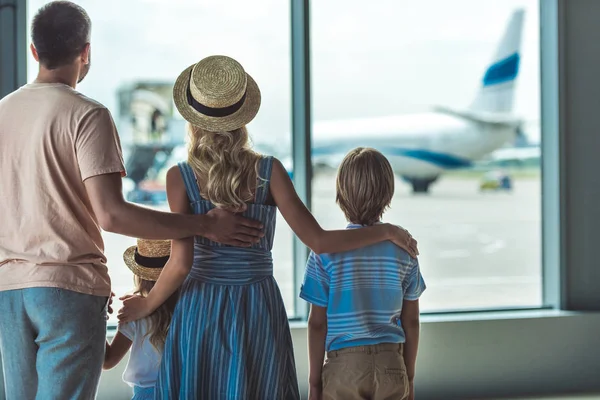 Familie schaut aus Fenster im Flughafen — Stockfoto