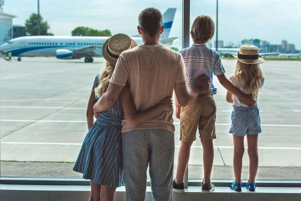 Família olhando para fora janela no aeroporto — Fotografia de Stock