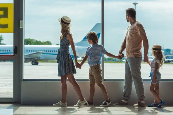 Familie schaut aus Fenster im Flughafen — Stockfoto