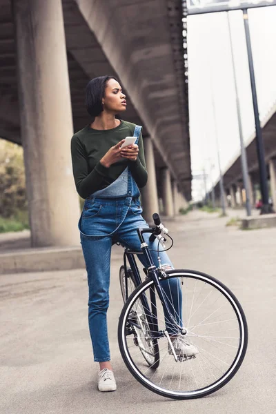 Femme à vélo avec smartphone — Photo de stock