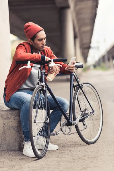 Homme avec vélo utilisant un smartphone — Photo de stock