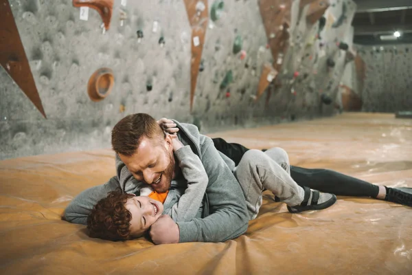 Dad knocking down son on mat — Stock Photo