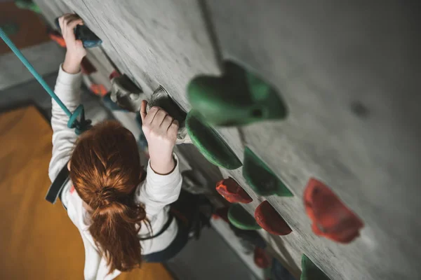 Ragazza arrampicata parete con impugnature — Foto stock