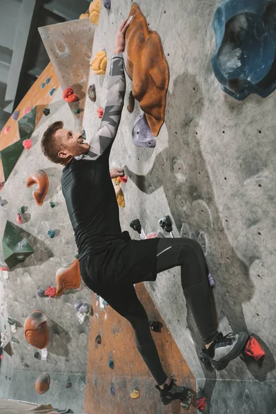 Homem parede de escalada com apertos — Fotografia de Stock