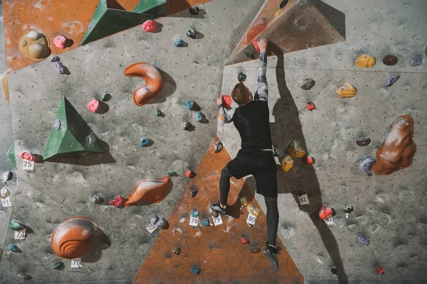 Man climbing wall with grips — Stock Photo