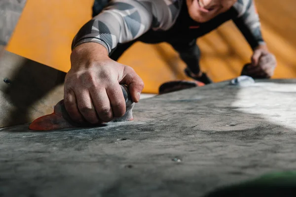 Man climbing wall with grips — Stock Photo