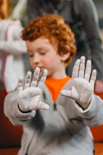 Niño mostrando las manos cubiertas de talco - foto de stock