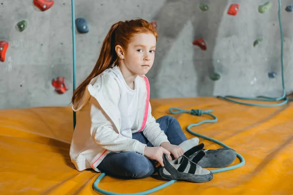 Little girl sitting on mat in gym — Stock Photo
