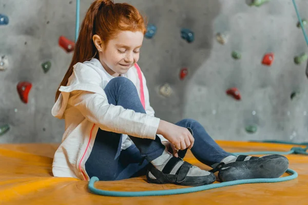 Little girl sitting on mat in gym — Stock Photo