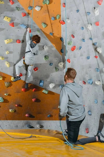 Ragazzino arrampicata parete con impugnature — Foto stock