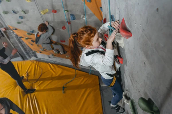 Kleines Mädchen klettert Wand mit Griffen — Stockfoto