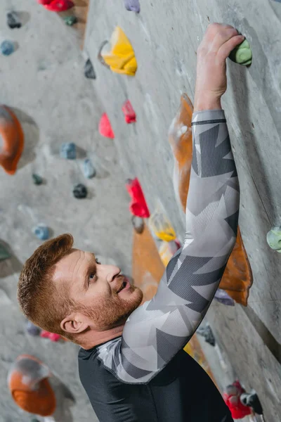 Man climbing wall with grips — Stock Photo