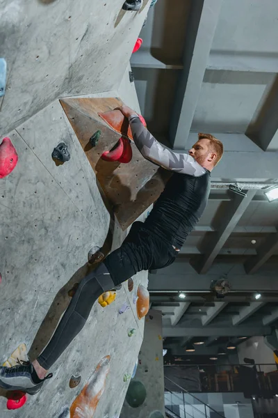 Man climbing wall with grips — Stock Photo