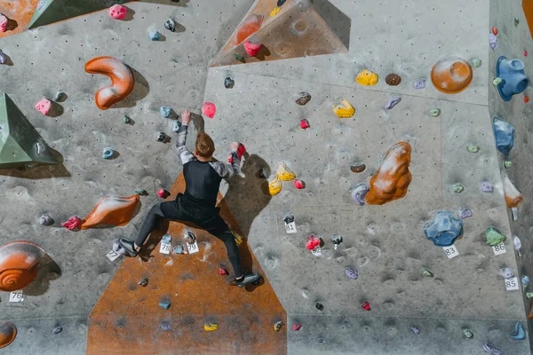 Hombre escalada pared con agarres - foto de stock