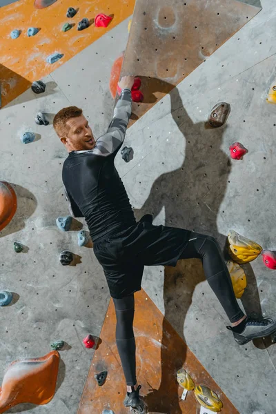 Mur d'escalade homme avec poignées — Photo de stock