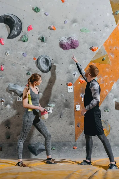 Junger Mann zeigt auf Kletterwand — Stockfoto