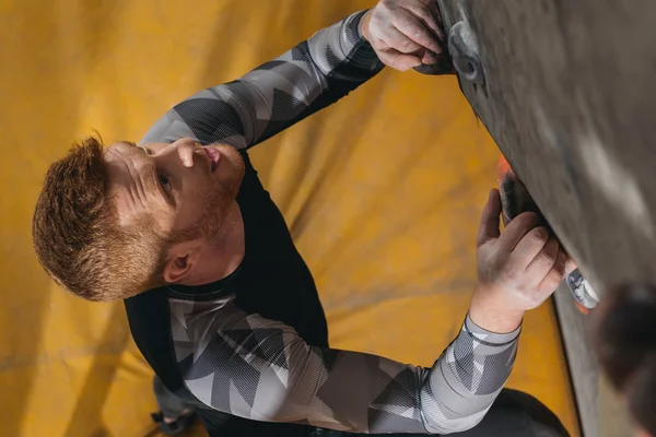 Man climbing wall with grips — Stock Photo