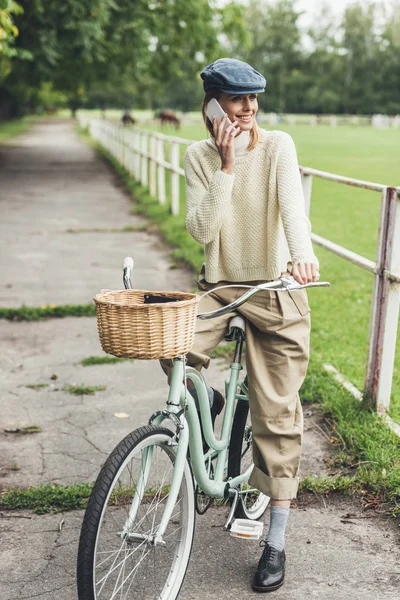 Жінка зі смартфоном на велосипеді — стокове фото