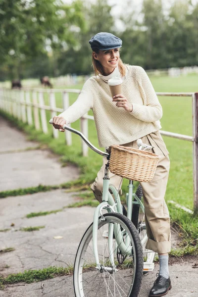 Mujer con café en bicicleta - foto de stock