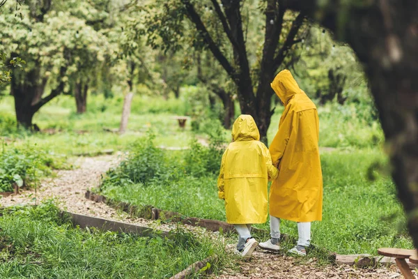 Family in raincoats at countryside — Stock Photo