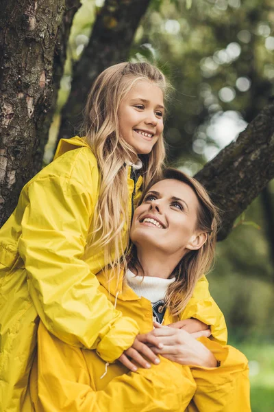 Madre piggybacking su hija - foto de stock