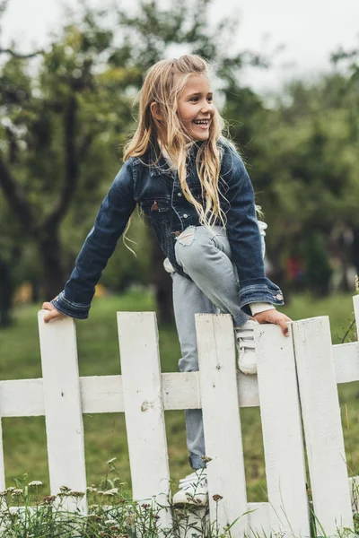 Enfant grimpant par-dessus la clôture — Photo de stock