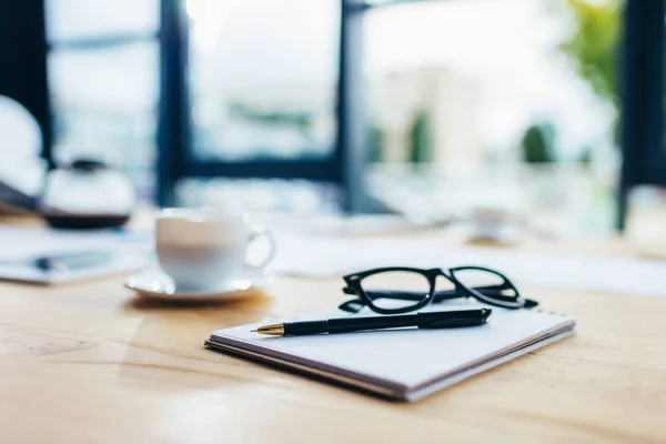 Eyeglasses with notebook and pen — Stock Photo