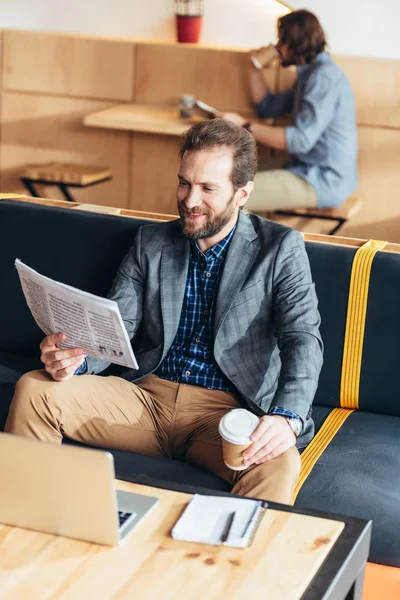 Uomo che legge giornali e beve caffè — Foto stock