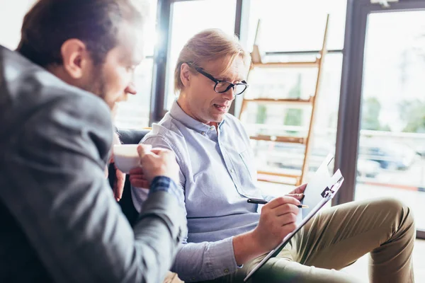 Uomini d'affari che lavorano e parlano nel caffè — Foto stock