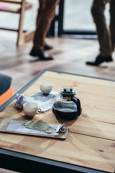 Café, dinero y periódico en la mesa - foto de stock