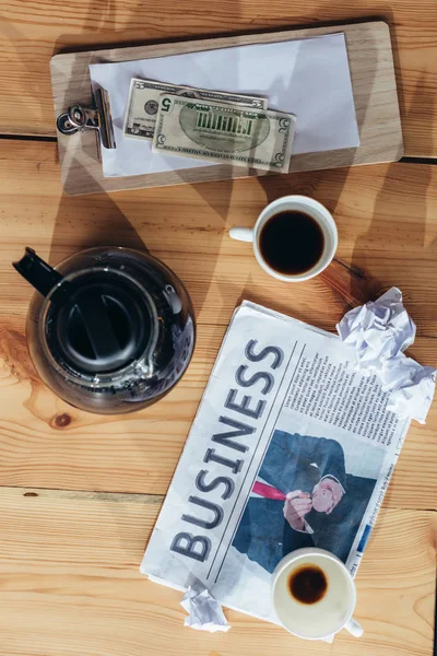 Kaffee, Geld und Zeitung auf dem Tisch — Stockfoto