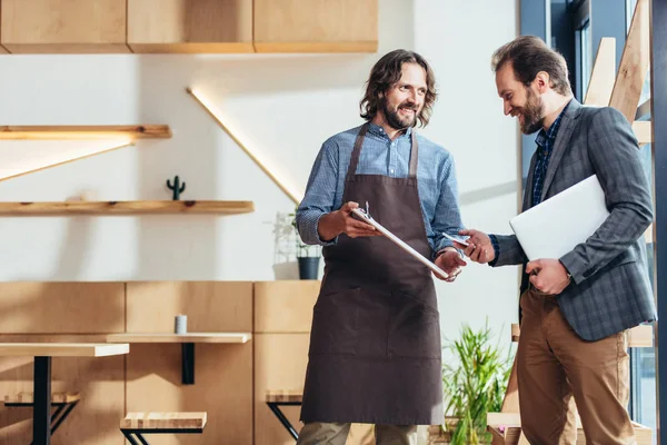 Businessman and waiter in cafe — Stock Photo