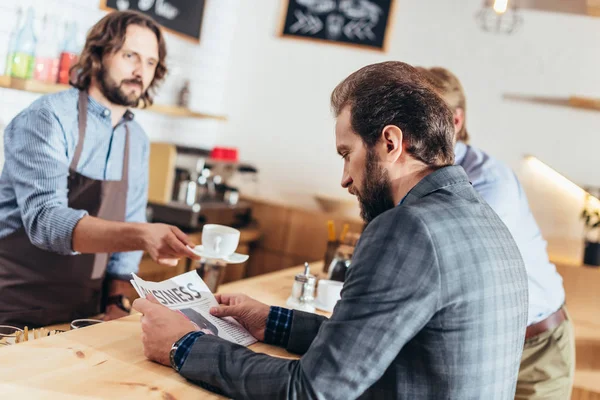 Uomo d'affari che legge giornale in caffè — Foto stock