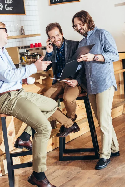 Hommes d'affaires travaillant et parlant dans un café — Photo de stock