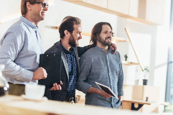 Hombres de negocios trabajando y hablando juntos - foto de stock