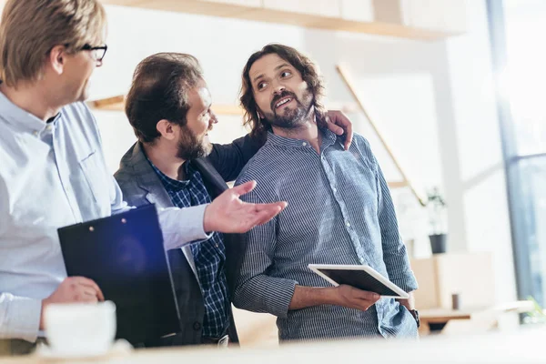 Hombres de negocios trabajando y hablando juntos - foto de stock