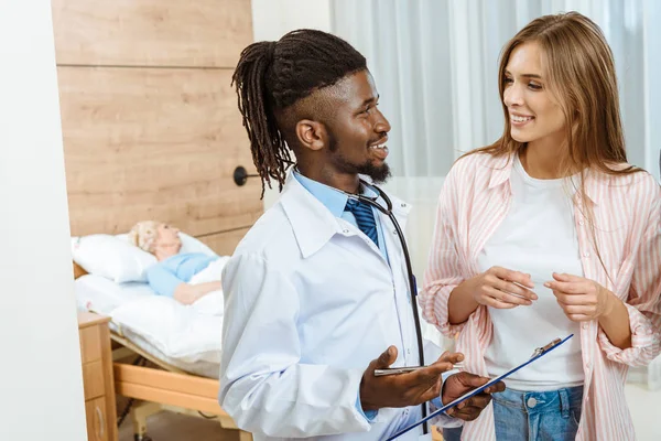 Young doctor talking to woman — Stock Photo