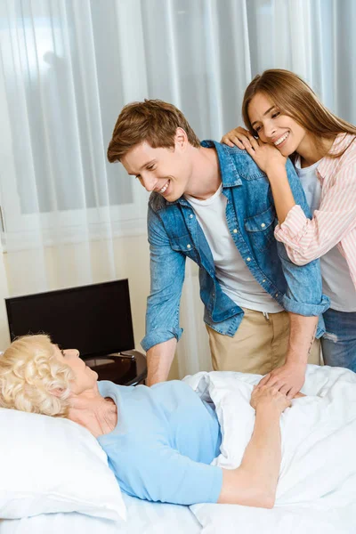 Couple visitant femme âgée malade — Photo de stock