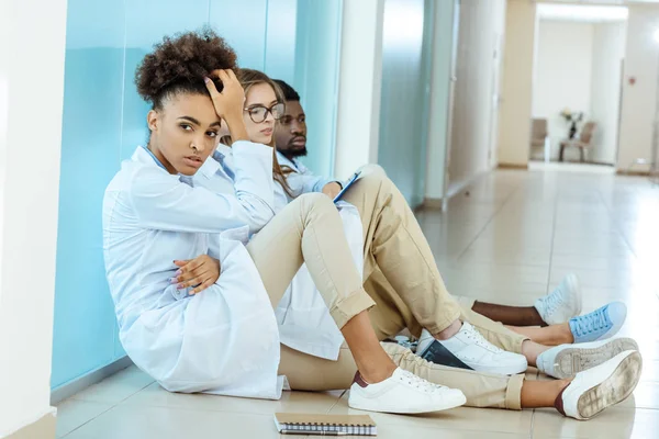 Doctors sitting on floor in hospital — Stock Photo