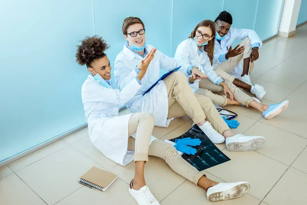 Smiling doctors sitting in hospital corridor — Stock Photo