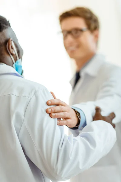 Doctor patting colleague on shoulder — Stock Photo