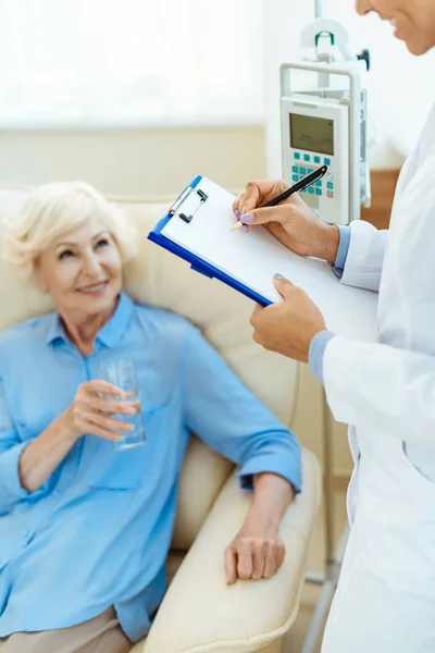 Elderly woman with doctor in hospital — Stock Photo