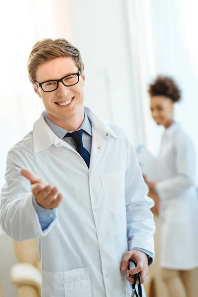 Усміхнений лікар тримає руку — стокове фото