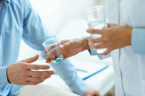 Woman handing pills to man — Stock Photo