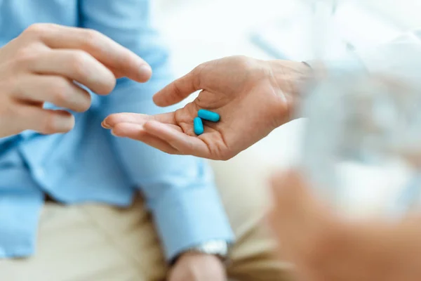 Hombre tomando pastillas de la mano - foto de stock