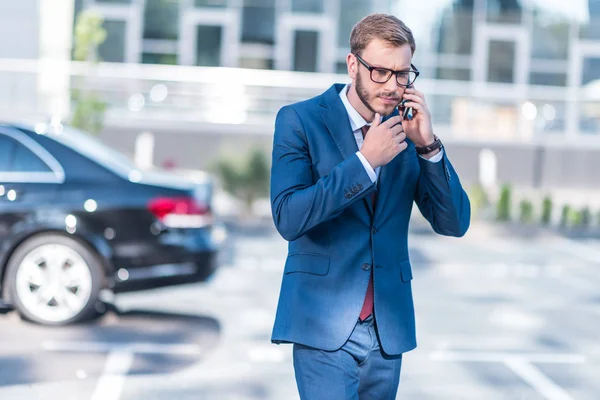 Uomo d'affari con smartphone sul parcheggio — Foto stock