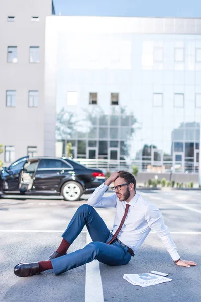 Gestresster Geschäftsmann sitzt auf Parkplatz — Stockfoto