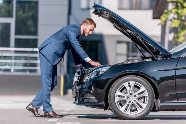 Uomo d'affari in tuta riparazione auto — Foto stock