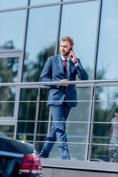 Businessman with smartphone at office building — Stock Photo